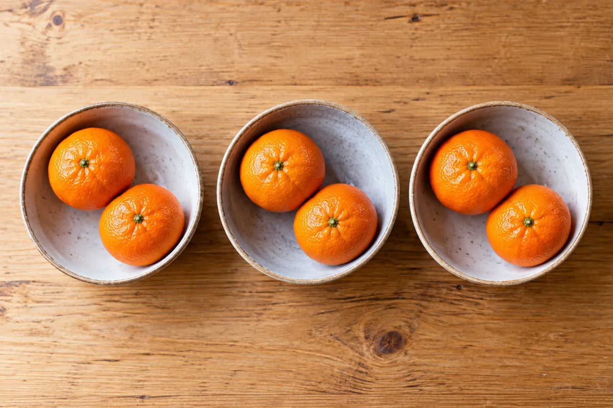 Three bowls with two clementines in each bowl